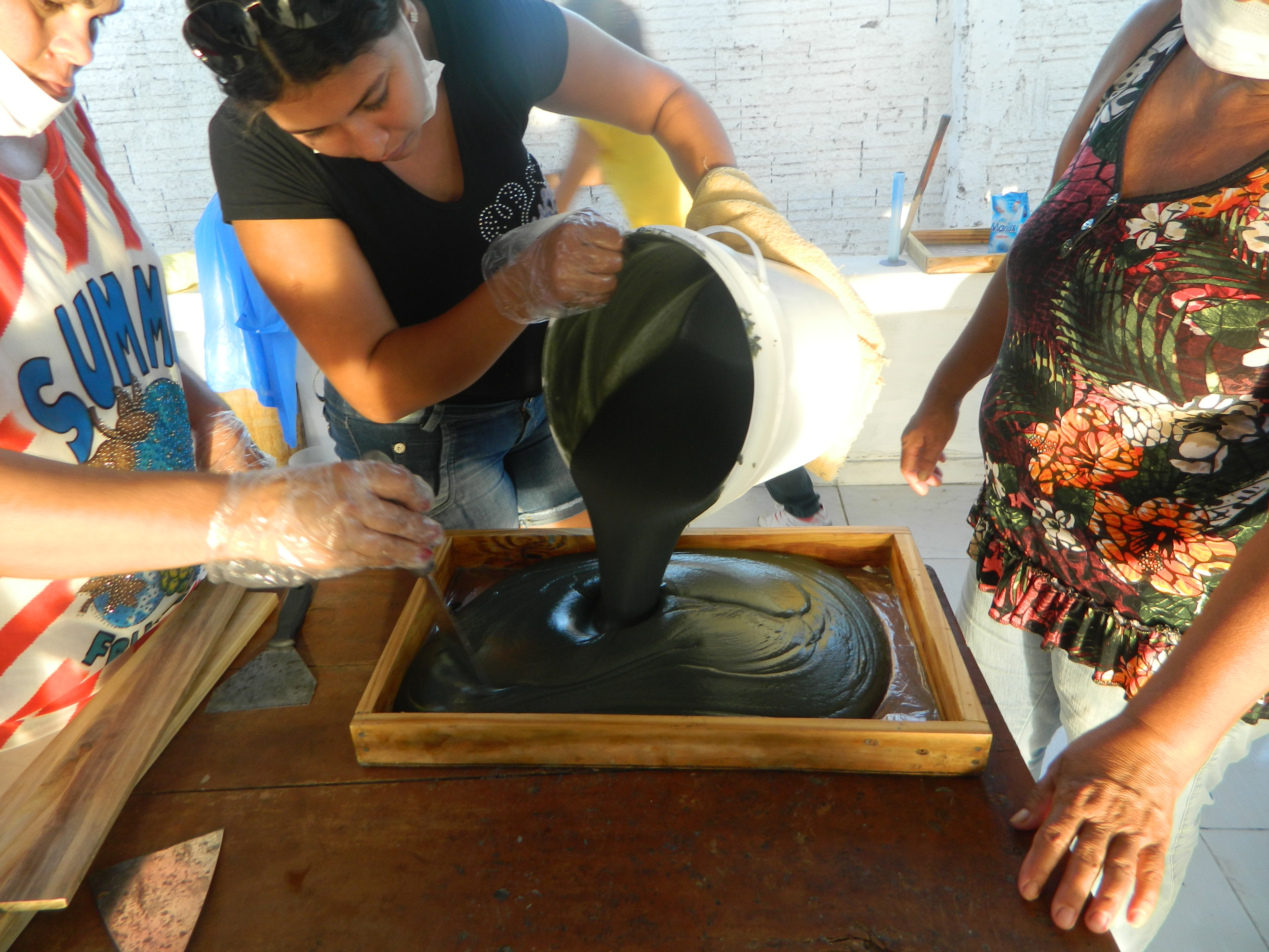 Mulher colocando sabão em líquido no recipiente de madeira
